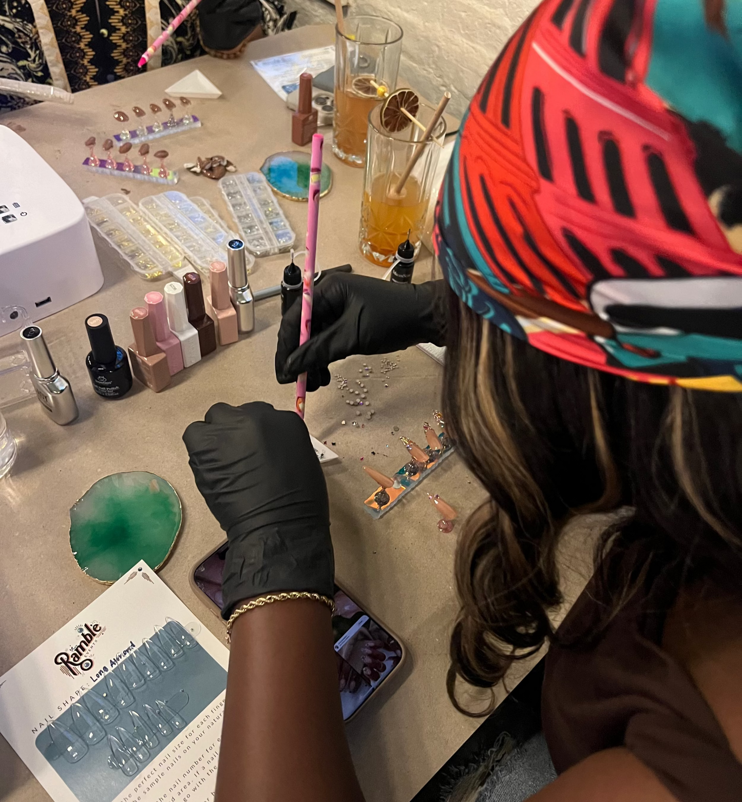 Person applying gems on press on nails with a rhinestone tool